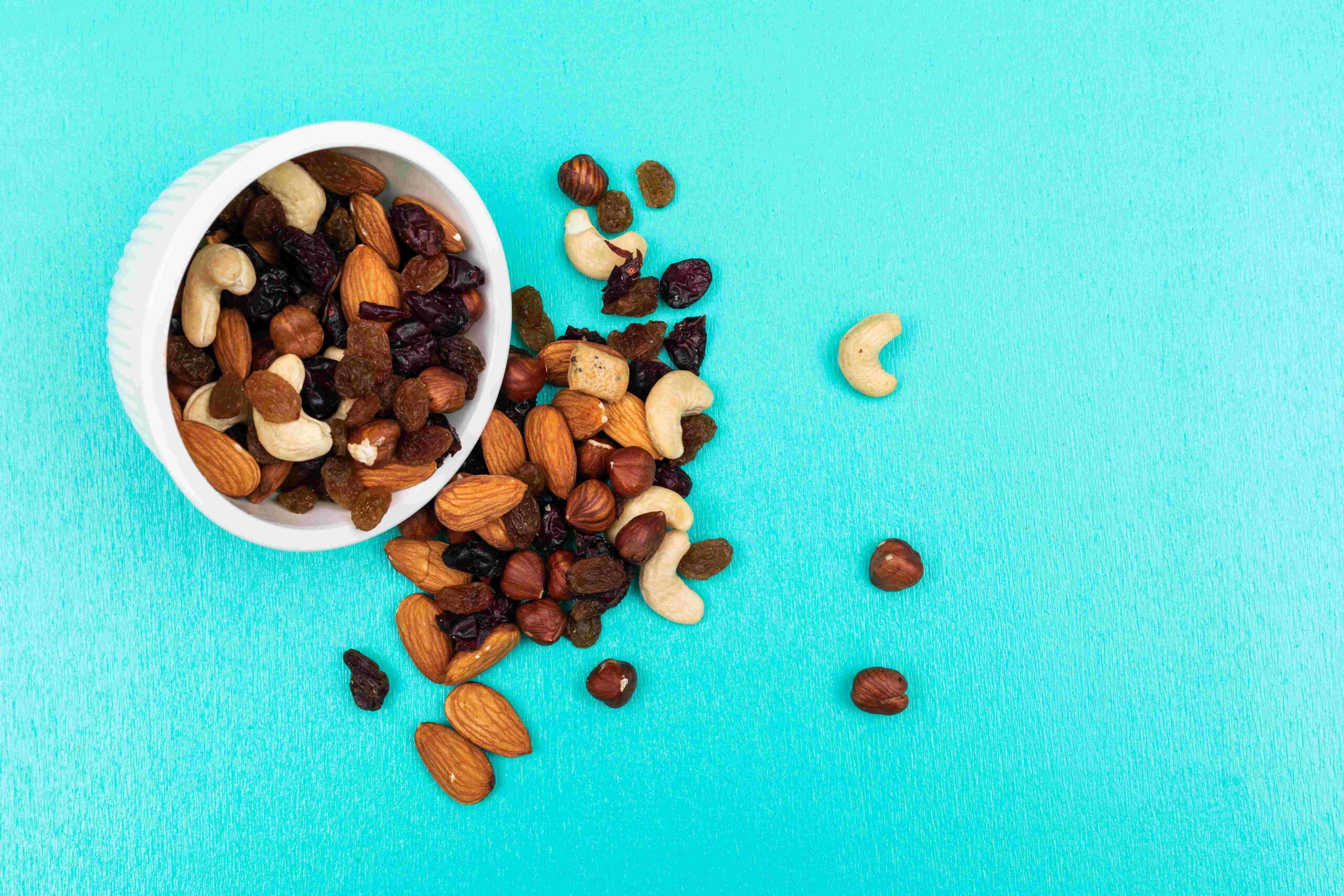 side-view-different-kind-snacks-as-nuts-with-dried-fruits-bowl-blue-background-horizontal1